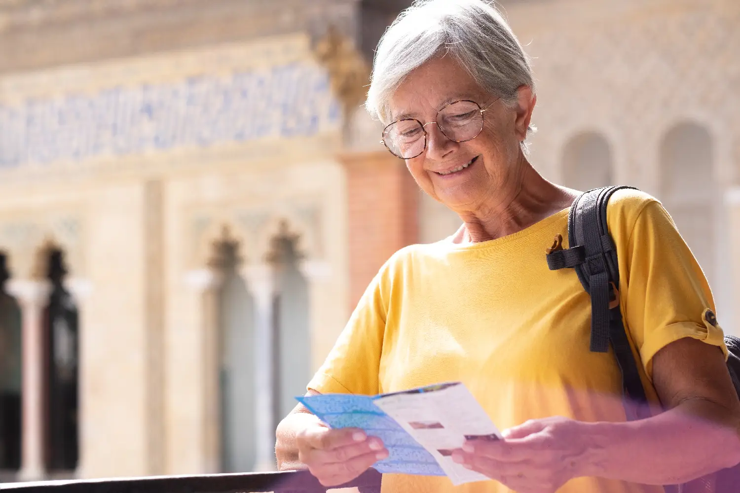 Starsza uśmiechnięta kobieta czytająca ulotkę wyborczą